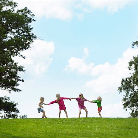 Girls playing tug-of-war in field Stock Photo - Premium Royalty-Free, Code: 6122-07702307