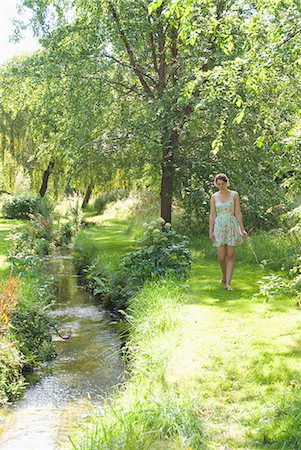 Girl picking flowers by river Stock Photo - Premium Royalty-Free, Code: 6122-07702498