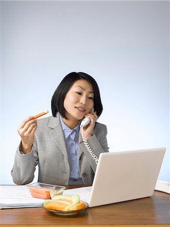 simsearch:614-02985267,k - Businesswoman eating and working at desk Stock Photo - Premium Royalty-Free, Code: 6122-07702995