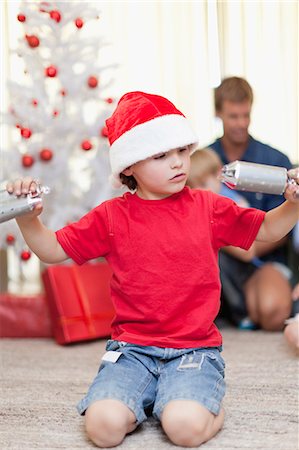 simsearch:640-03260410,k - Boy opening Christmas cracker by himself Stock Photo - Premium Royalty-Free, Code: 6122-07703077