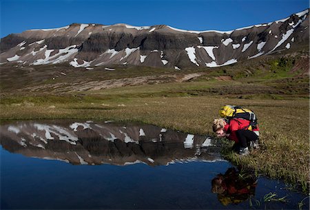 simsearch:632-05604251,k - Hiker admiring reflection in still pond Photographie de stock - Premium Libres de Droits, Code: 6122-07703232