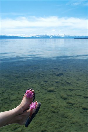 Woman dangling feet over still lake Stock Photo - Premium Royalty-Free, Code: 6122-07703355