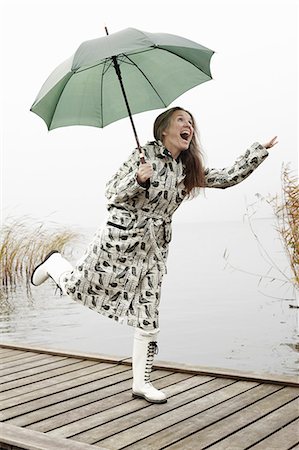 simsearch:6113-06899628,k - Older woman carrying umbrella on dock Stock Photo - Premium Royalty-Free, Code: 6122-07703874