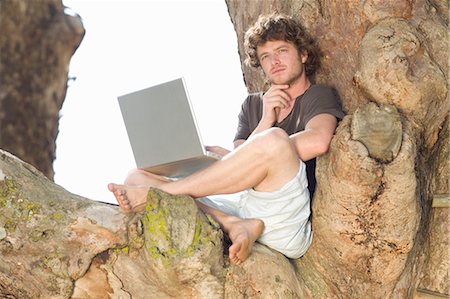 simsearch:6113-06753440,k - Pensive man using laptop in tree Stock Photo - Premium Royalty-Free, Code: 6122-07703963