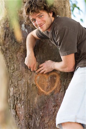 simsearch:649-06717611,k - Smiling man carving heart in tree Foto de stock - Sin royalties Premium, Código: 6122-07703969