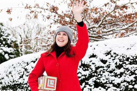 simsearch:649-06532718,k - Woman carrying wrapped gift in snow Stock Photo - Premium Royalty-Free, Code: 6122-07704062