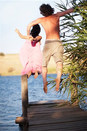 simsearch:6122-07699789,k - Couple jumping off dock into lake Stock Photo - Premium Royalty-Free, Code: 6122-07704014