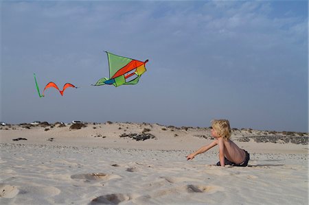 Boy flying kite on beach Stock Photo - Premium Royalty-Free, Code: 6122-07704154