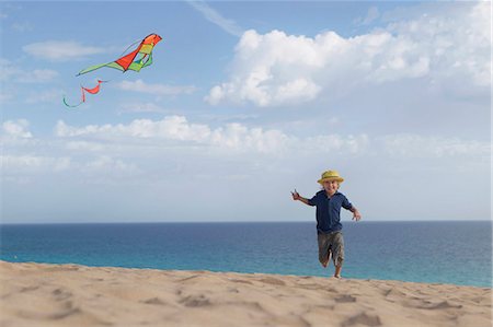flying kite kids running - Boy flying kite on beach Stock Photo - Premium Royalty-Free, Code: 6122-07704163
