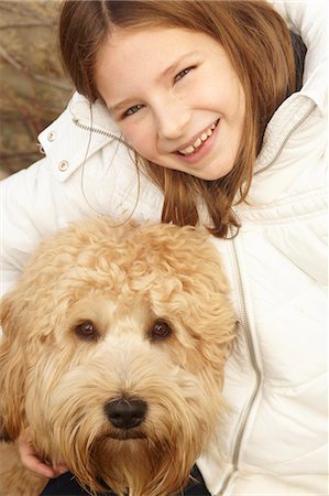 simsearch:649-06401393,k - Smiling girl petting dog outdoors Stock Photo - Premium Royalty-Free, Code: 6122-07704412