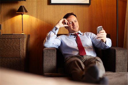 Businessman on cell phone in hotel room Stock Photo - Premium Royalty-Free, Code: 6122-07704437
