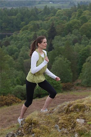 Woman climbing rural hill Stock Photo - Premium Royalty-Free, Code: 6122-07704522