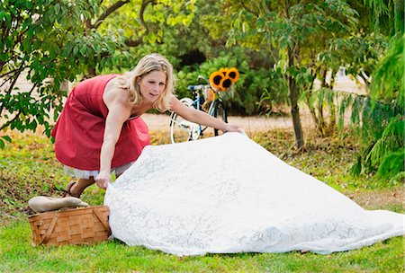 picnicking - Woman laying out picnic blanket Stock Photo - Premium Royalty-Free, Code: 6122-07704881