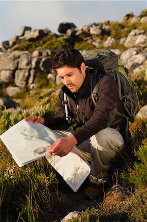 Hiker reading map in rocky field Stock Photo - Premium Royalty-Free, Code: 6122-07705017
