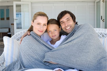 simsearch:6108-05872072,k - Family relaxing on sofa under blanket Stock Photo - Premium Royalty-Free, Code: 6122-07705573