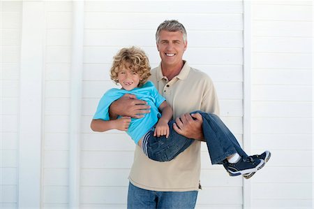 simsearch:649-05649029,k - Smiling man carrying son outdoors Stock Photo - Premium Royalty-Free, Code: 6122-07705579