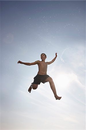 preteen swim - Boy posing in mid-air Stock Photo - Premium Royalty-Free, Code: 6122-07705999