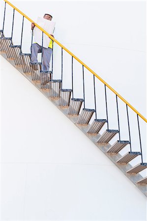 simsearch:6122-07706261,k - Worker climbing steps at chemical plant Foto de stock - Sin royalties Premium, Código: 6122-07706303