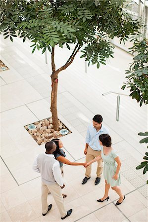 simsearch:6122-07706325,k - Business people shaking hands in lobby Stock Photo - Premium Royalty-Free, Code: 6122-07706333