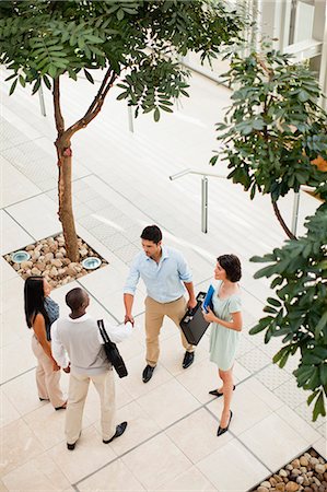 simsearch:6122-07706325,k - Business people shaking hands in lobby Stock Photo - Premium Royalty-Free, Code: 6122-07706334