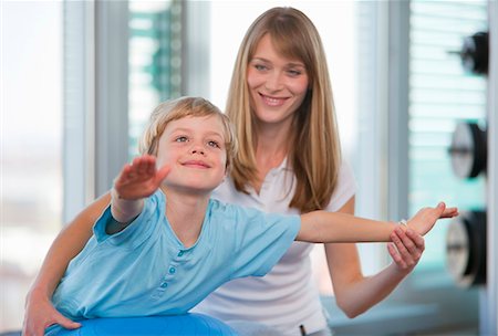 simsearch:649-06433566,k - Trainer working with boy in gym Photographie de stock - Premium Libres de Droits, Code: 6122-07706457