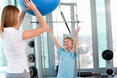 simsearch:649-06041068,k - Trainer working with boy in gym Stock Photo - Premium Royalty-Free, Code: 6122-07706454