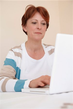 simsearch:6113-07730780,k - Smiling woman using laptop Stock Photo - Premium Royalty-Free, Code: 6122-07706428