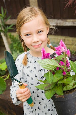 simsearch:6122-07698204,k - Smiling girl planting flowers outdoors Stock Photo - Premium Royalty-Free, Code: 6122-07706545