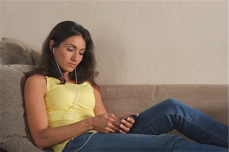 simsearch:6113-07731119,k - Woman listening to headphones on sofa Stock Photo - Premium Royalty-Free, Code: 6122-07707162