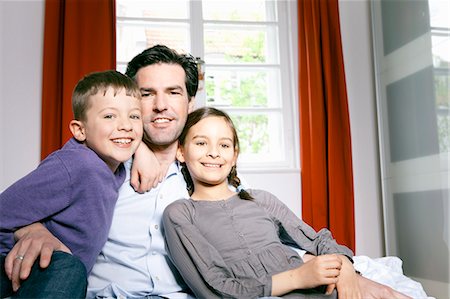 father hugging his son and daughter - Father and children smiling together Stock Photo - Premium Royalty-Free, Code: 6122-07707197