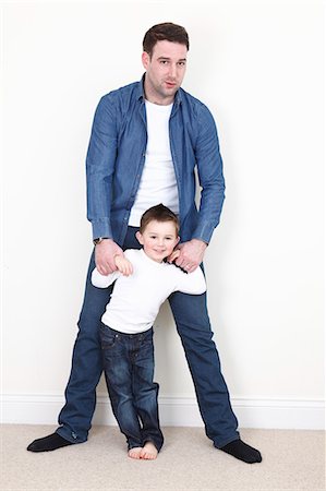 family white background full body - Man standing with son indoors Stock Photo - Premium Royalty-Free, Code: 6122-07707293