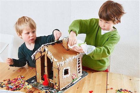 Boys decorating gingerbread house Stock Photo - Premium Royalty-Free, Code: 6122-07707398