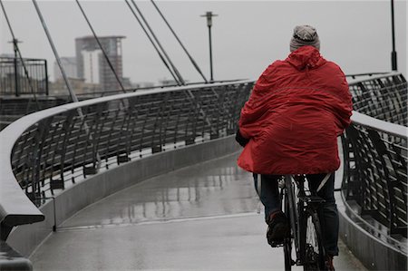 poncho - Back view of man with raincoat cycling Stock Photo - Premium Royalty-Free, Code: 6122-08211872