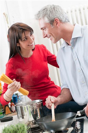 Smiling couple cooking together Stock Photo - Premium Royalty-Free, Code: 6122-08211880