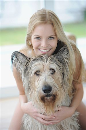simsearch:649-05800987,k - Smiling woman hugging dog at home Stock Photo - Premium Royalty-Free, Code: 6122-08212199
