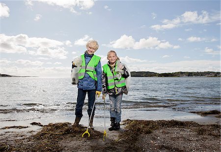 Children in safety vests cleaning beach Stock Photo - Premium Royalty-Free, Code: 6122-08212244