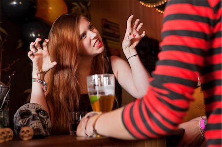 Young woman pulling faces at friend in bar Stock Photo - Premium Royalty-Free, Code: 6122-08212762