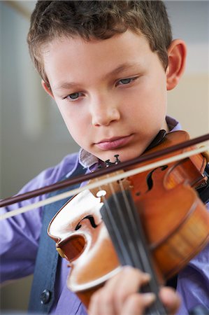 Serious boy playing violin Stock Photo - Premium Royalty-Free, Code: 6122-08229054