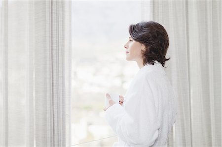 simsearch:649-05521576,k - Woman in bathrobe looking out window Stock Photo - Premium Royalty-Free, Code: 6122-08229199