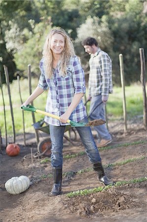 smiling couple in vegetable garden - Woman shoveling dirt in garden Stock Photo - Premium Royalty-Free, Code: 6122-08229220