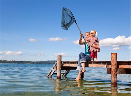 Mother and daughter fishing with net Stock Photo - Premium Royalty-Free, Code: 6122-08229337