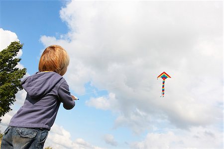 Boy flying kite outdoors Stock Photo - Premium Royalty-Free, Code: 6122-08229462