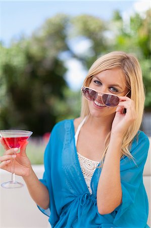 smiling one person - Smiling woman having cocktail outdoors Stock Photo - Premium Royalty-Free, Code: 6122-08229491