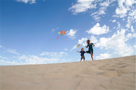 flying kite kids running - Mother and son flying kite on beach Stock Photo - Premium Royalty-Free, Code: 6122-08229751