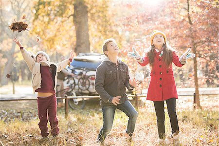 simsearch:649-05657687,k - Boys and girl throwing autumn leaves overhead in woods Photographie de stock - Premium Libres de Droits, Code: 6124-08170370