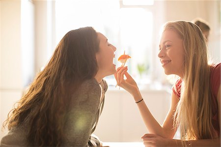 simsearch:6113-06908601,k - Teenage girl feeding friend sushi with chopsticks Stock Photo - Premium Royalty-Free, Code: 6124-08170478