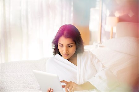 simsearch:6113-07731119,k - Woman in bathrobe using digital tablet on bed Stock Photo - Premium Royalty-Free, Code: 6124-08170598