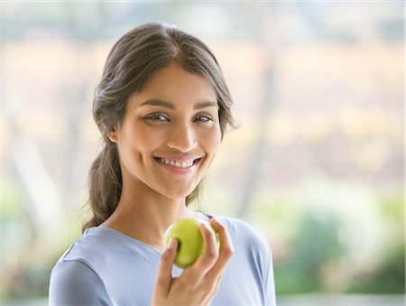 simsearch:614-07806265,k - Close up portrait smiling woman eating green apple Stock Photo - Premium Royalty-Free, Code: 6124-08170712