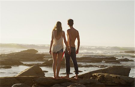 simsearch:841-03518373,k - Young couple holding hands and looking at ocean view Stock Photo - Premium Royalty-Free, Code: 6124-08658134