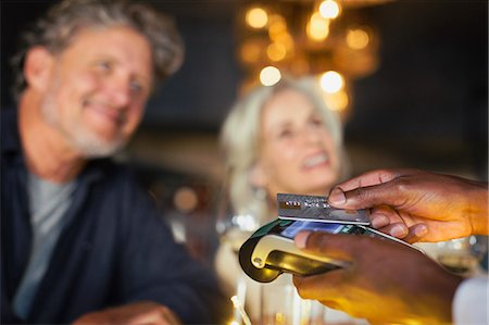 simsearch:6108-06907863,k - Close up couple paying waiter with credit card reader Stock Photo - Premium Royalty-Free, Code: 6124-08743210